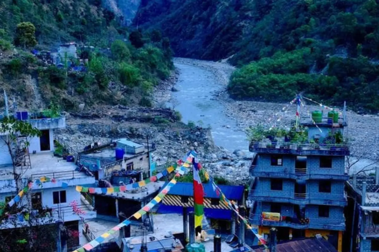 Colorful prayer flags strung across the small village of Jagat overlooking a rocky river valley on the popular Annapurna Circuit trek.